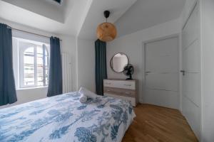 a bedroom with a blue and white bed and a window at Le Wilson - Appartement design - Hyper centre in Vichy +30 photos