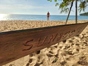 a sign on the beach with a person in the background at SunBoo Beach Bungalows in Koh Rong Sanloem