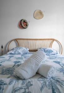 a bed with a blue and white blanket and two pillows at Le Wilson - Appartement design - Hyper centre in Vichy