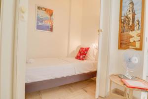 a small bedroom with a bed and a fan at « Hawai » Proche Mer, Calme, Piscine in Menton
