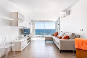 a living room with a couch and a view of the ocean at Luxury First Line Apartment. in Salinetas