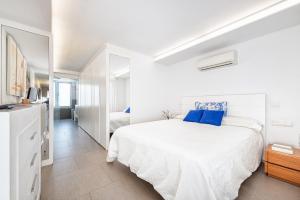 a white bedroom with a large bed with blue pillows at Luxury First Line Apartment. in Salinetas