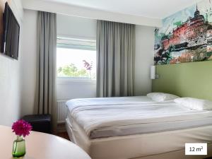 una camera d'albergo con letto e finestra di Good Morning Örebro a Örebro