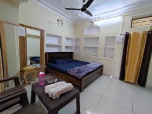 Cette petite chambre comprend un lit et une table. dans l'établissement OYO Ambika Guest House, à Pushkar