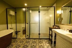 een badkamer met een douche, een bad en een wastafel bij Guangzhou Nansha Stone Inn in Guangzhou
