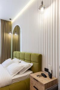 een slaapkamer met een groen bed en een houten tafel bij Avangard on Leinberg St 7 Apart in Lviv