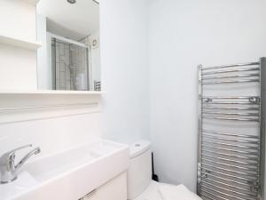 een witte badkamer met een wastafel en een spiegel bij Pass the Keys Headington 4BR Home Parking and Garden Oxford in Oxford