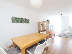 a dining room with a wooden table and white chairs at Pass the Keys Headington 4BR Home Parking and Garden Oxford in Oxford
