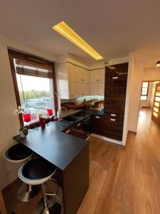 a kitchen with a black counter and stools in it at Apartament City Warszawa in Warsaw