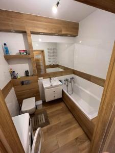 a bathroom with a tub and a sink and a toilet at Apartament City Warszawa in Warsaw
