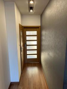 a hallway with a door and a wooden floor at Apartament City Warszawa in Warsaw