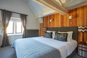 1 dormitorio con 1 cama grande y paredes de madera en Timbrell's Yard, en Bradford on Avon