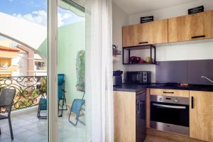 a kitchen with a view of a balcony at Appartement T2 entièrement rénové in Saint-Cyr-sur-Mer