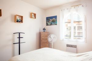 sypialnia z białym łóżkiem i oknem w obiekcie Appartement T2 entièrement rénové w mieście Saint-Cyr-sur-Mer