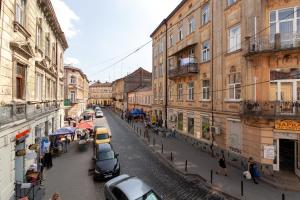 une rue de la ville avec des voitures garées sur le côté de la route dans l'établissement Avangard on Shpytalna St 30 Apart, à Lviv