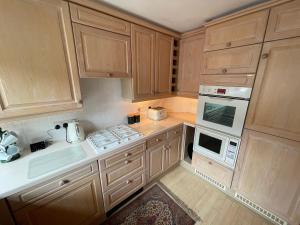 une cuisine avec des armoires en bois, un évier et une cuisinière dans l'établissement Circus Mews Townhouse:2 Beds:2 En-suite Baths:Parking:City Centre:Quiet Area, à Bath