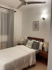 1 dormitorio con 1 cama, 2 lámparas y ventana en 3-bedroom apartment by Mas, en Dar es Salaam