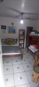 sypialnia z łóżkiem i podłogą wyłożoną kafelkami w obiekcie Suite de Lane e Mu w mieście Abraão