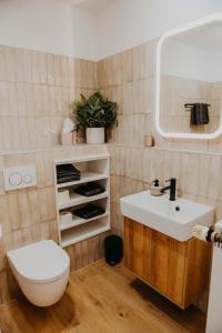 uma casa de banho com um lavatório branco e um WC. em sleepArt hygge em Celle