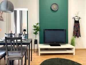 a living room with a tv on a white table at Piotrkowska Studio Apartments in Łódź
