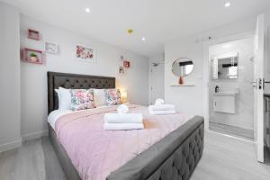 - une chambre avec un grand lit et des serviettes dans l'établissement Stunning Ensuite Room Crystal Palace London SE20, à Londres