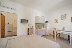 Cet appartement comprend une chambre avec un lit et une table ainsi qu'une cuisine. dans l'établissement A Casa di Coco - Goelba, à Portoferraio