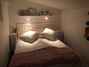 a bedroom with a bed with white sheets and pillows at Havsnära stuga, Falkenberg in Falkenberg