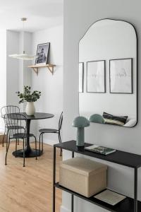 a living room with a table and a mirror at Cozy 2 bedroom apartment with patio in Madrid