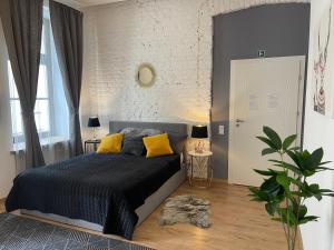 a bedroom with a bed and a white brick wall at Piotrkowska Studio Apartments in Łódź