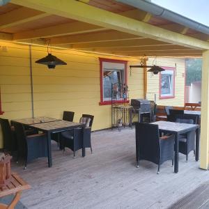 eine Außenterrasse mit Tischen, Stühlen und einem Grill in der Unterkunft B&B Waldcafe in Altenau