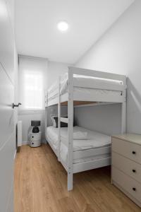 a white bedroom with two bunk beds in it at Cozy 2 bedroom apartment with patio in Madrid