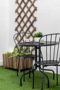 a black table and chairs with green grass at Cozy 2 bedroom apartment with patio in Madrid