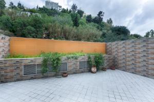 a brick retaining wall with plants in a courtyard at Tangier Center Free Parking in Tangier +1 photo