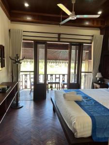une chambre avec un lit avec un ventilateur de plafond dans l'établissement Namkhan Riverview Aphay, à Luang Prabang
