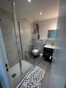 a bathroom with a shower and a toilet and a sink at LE GALION in La Baule