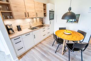 a kitchen with a wooden table and black chairs at Steger-Hüs Wohnung 02 in Rantum +13 photos