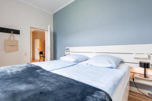 ラントゥムにあるSteger-Hüs Wohnung 04のベッドが2つあり、青い壁の寝室