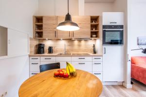 a kitchen with a wooden table with a bowl of fruit at Steger-Hüs Wohnung 10 in Rantum +11 photos