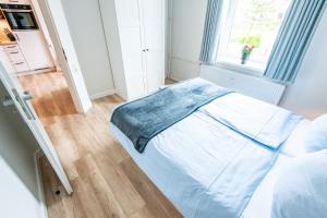 a white bed in a room with a window at Steger-Hüs Wohnung 10 in Rantum