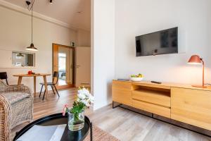 a living room with a tv on a wall at Steger-Hüs Wohnung 13 in Rantum +11 photos