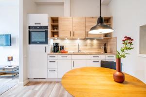 a kitchen with a wooden table and a white refrigerator at Steger-Hüs Wohnung 09 in Rantum