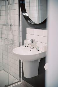 a bathroom with a white sink and a mirror at The 1852 Hotel - Self Check-in in Belfast