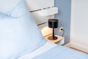 um quarto com uma cama com um candeeiro numa mesa de cabeceira em Steger-Hüs Wohnung 12 em Rantum