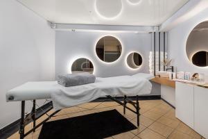 トシェンサチにあるVilla Hoff Wellness & Spaのベッド1台と円形の窓2つが備わる客室です。