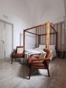 a bedroom with a bed and a couple of chairs at Dimora San Biagio Suites&Apartment in Lecce