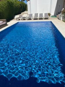 a swimming pool with blue water in a house at Villa Zen in Albufeira