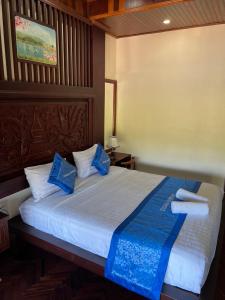 une chambre avec un grand lit avec des oreillers bleus dans l'établissement Namkhan Riverview Aphay, à Luang Prabang 21 autres photos