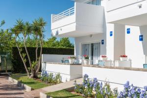 a white house with flowers on the side of it at Apartamentos Solecito in Port d'Alcudia