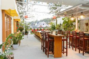 VANDA VIilla Garden trung tâm في دالات: مطعم بطاولات خشبية وكراسي ونباتات