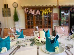 VANDA VIilla Garden trung tâm في دالات: طاولة عليها مناديل زرقاء وكؤوس للنبيذ